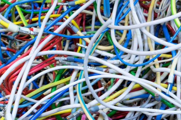 Fototapeta The bunch of electric wires of different colors with cable lugs. Wires and cables are very much mixed up and intertwined. Flexible wire with copper conductor. Disorder and chaos.