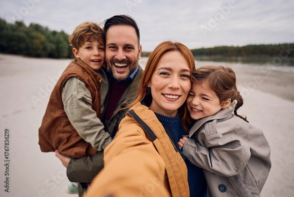 Fototapeta Happy family having fun while taking selfie in autumn day in nature.