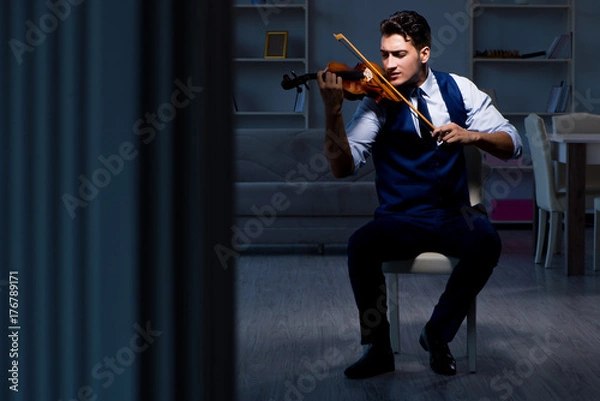 Fototapeta Young musician man practicing playing violin at home