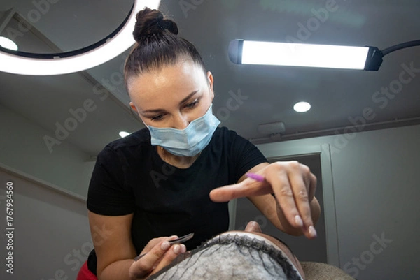 Obraz A specialist laminating and styling eyebrows and eyelashes. Beauty salon cosmetology procedures