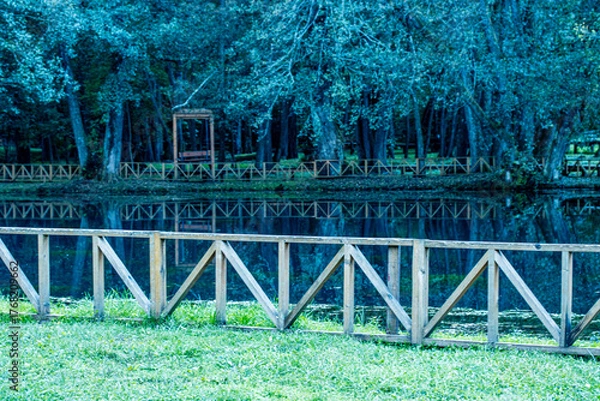 Fototapeta Curved Wooden Fence in Green Forest Park