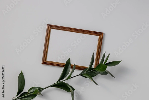 Fototapeta Empty brown wood border, with craft paper and green branches isolated on white table background.