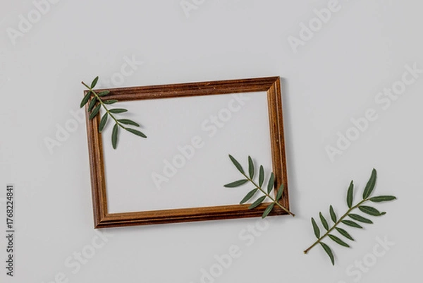 Fototapeta Empty brown wood border, with craft paper and green branches isolated on white table background.