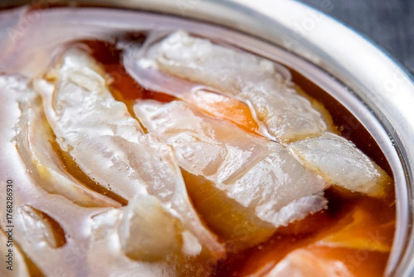 Obraz 生魚の切り身を漬けダレに漬ける調理シーン。
