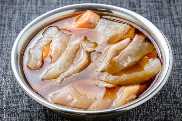 Obraz 生魚の切り身を漬けダレに漬ける調理シーン。
