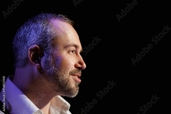 Fototapeta Profile of smiling actor talking on black background