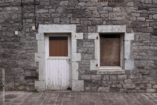 Obraz Old Window in Brick Wall
Weathered window framed by aged, cracked, and neglected bricks.
