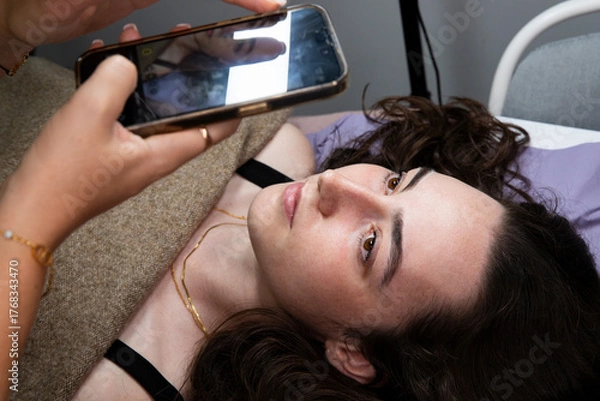 Obraz A lash technician takes a photo of the eyes after the eyelash lamination procedure. Beauty salon: cosmetology procedures