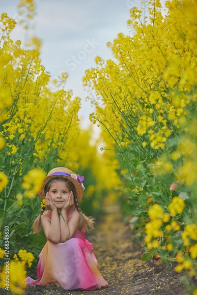 Fototapeta charming child in sundress in a rapeseed field