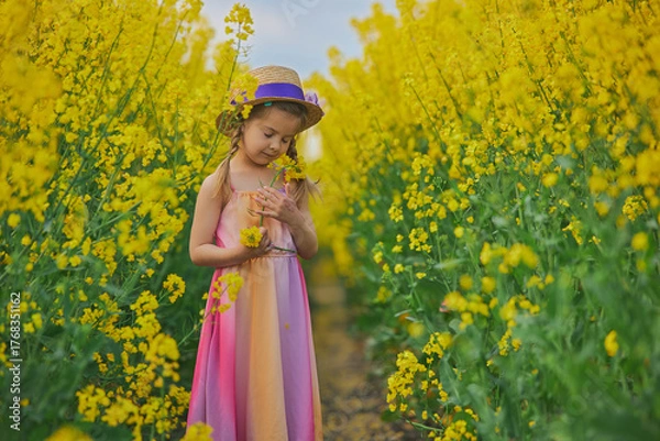 Fototapeta charming child in sundress in a rapeseed field