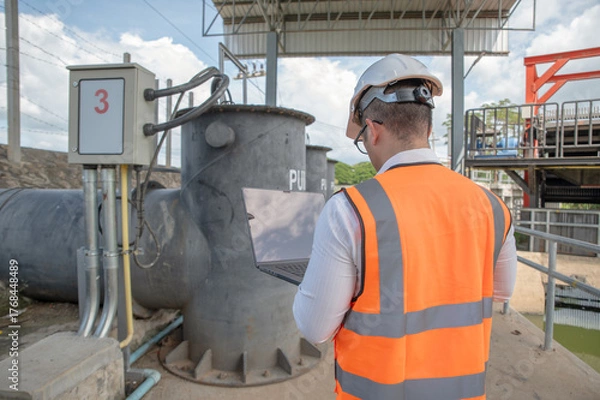 Fototapeta engineer is inspecting the area around the water control plant and inspecting the water storage tank
