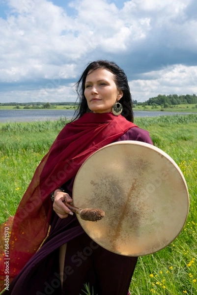 Fototapeta Portrait of a middle-aged shaman woman with a red headscarf in the natural environment