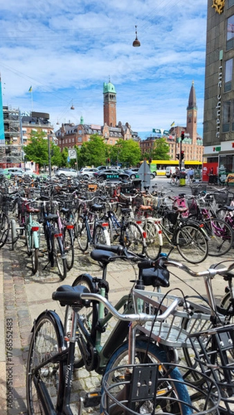 Fototapeta 06 August, 2024, Copenhagen city center, Denmark Summer day scenic canal with boats and tourists, cyclists riding along colorful buildings and waterfront, vibrant urban atmosphere in European capital