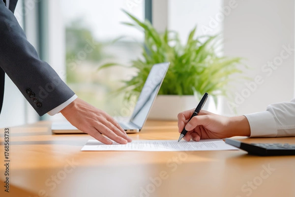 Obraz Client signs agreement in modern office setting during business meeting