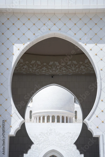 Fototapeta Architectural detail of white mosque framed by shade and arcs, United Arab Emirates