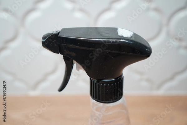 Obraz Close-up of a black spray bottle nozzle, highlighting its trigger and design against a blurred backdrop