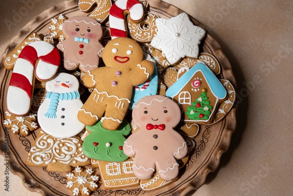 Fototapeta Gingerbread cookies with icing decoration. Christmas food. Gingerbread man baking. Top view table plate. Xmas sweets