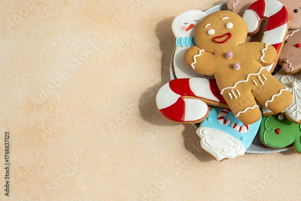 Fototapeta Gingerbread cookies with icing decoration. Christmas food. Gingerbread man baking. Top view table. Xmas sweet on biege background copy spase.