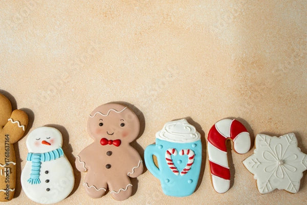 Fototapeta Gingerbread cookies with icing decoration. Christmas food. Gingerbread snowman baking. Top view table. Xmas sweet copy space background.