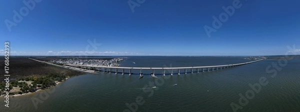 Fototapeta Aerial View Of Washington Baum Bridge Over Calm Water of Roanoke Sound Connecting Roanoke Island to Nags Head on the Outer Banks. Bright blue sky, tranquil water, urban-seaside scene.