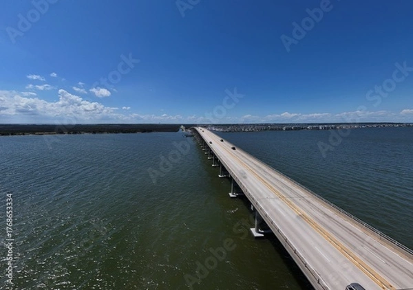 Fototapeta Aerial View Of Washington Baum Bridge Over Calm Water of Roanoke Sound Connecting Roanoke Island to Nags Head on the Outer Banks. Bright blue sky, tranquil water, urban-seaside scene.