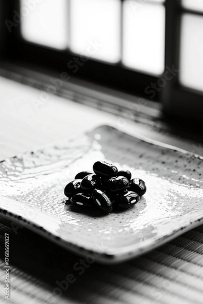 Obraz Black beans on ceramic plate in minimalist black and white japanese setting