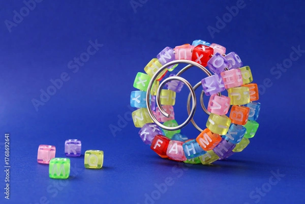 Obraz Colorful cubes with letters on a metal spiral, learning curve