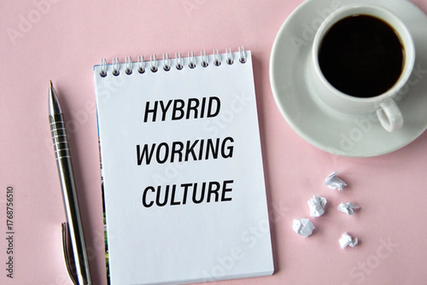 Fototapeta HYBRID WORKING CULTURE - words in a notebook on a pink background with a cup of coffee