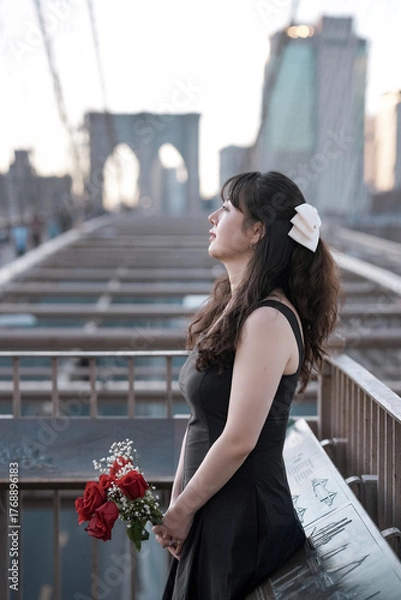 Obraz woman holding flowers standing on a beautiful bridge