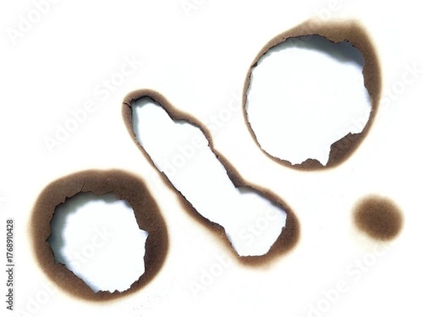 Fototapeta Close up of burned hole on white paper background. Black burn mark and scorched paper texture. A piece of scorched and torn paper with a fire burned hole and black scorch marks with stain.