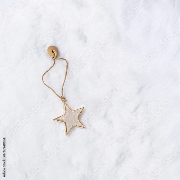 Fototapeta Christmas bauble shiny golden star in beige gold tones, flat lay on white fur. Festive holiday chrome metallic decoration, minimal style. Xmas greeting cards, new year aesthetic background, copyspace