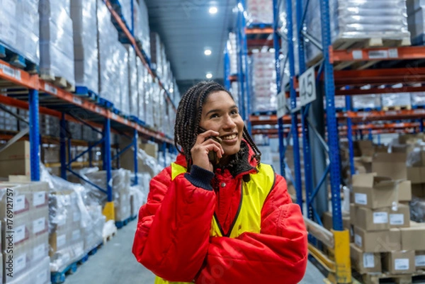Fototapeta Woman warehouse worker receiving phone call in cold storage