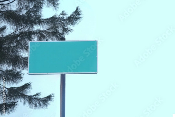 Fototapeta Blank Green Street Sign with Tree and Bright Sky Background