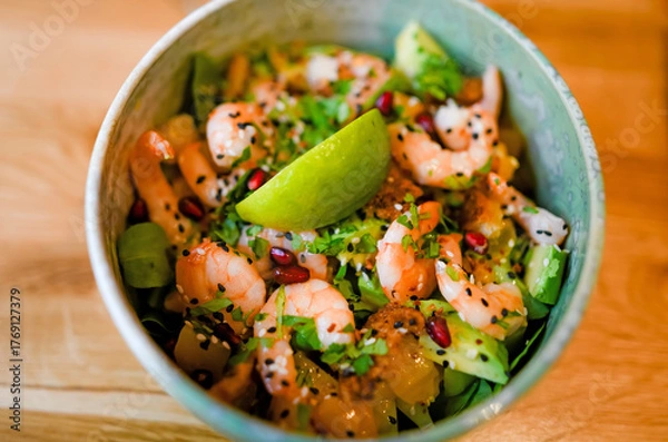 Fototapeta Bowl of salad with fresh shrimp, lemon, and cilantro
