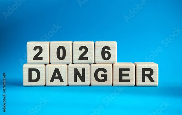 Fototapeta New year Danger 2026 concept. Wooden cubes on a blue background