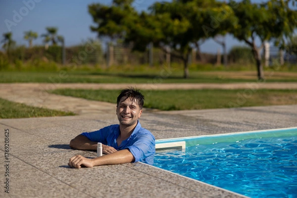 Fototapeta A Joyful Man is Enjoying a Relaxing and Peaceful Moment by the Poolside on a Sunny Day