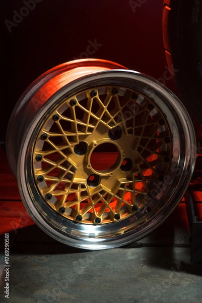 Fototapeta old retro stylish wheels collapsible two-component with a gold center and shiny rims for car tuning long exposure photo to simulate movement