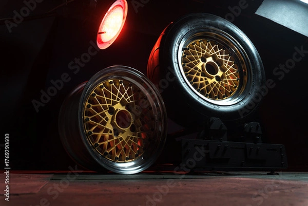Fototapeta old retro stylish wheels collapsible two-component with a gold center and shiny rims for car tuning long exposure photo to simulate movement