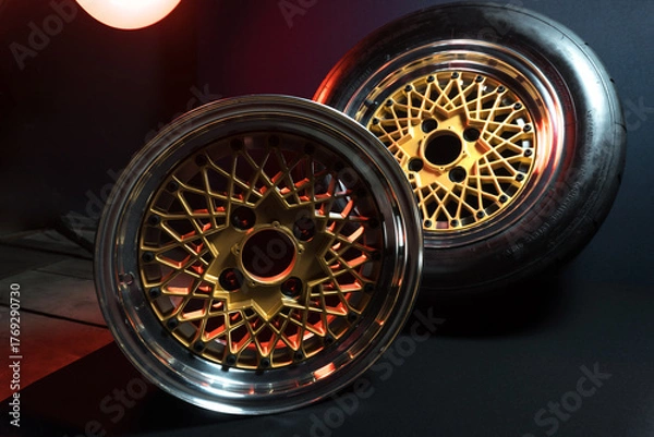 Fototapeta old retro stylish wheels collapsible two-component with a gold center and shiny rims for car tuning long exposure photo to simulate movement