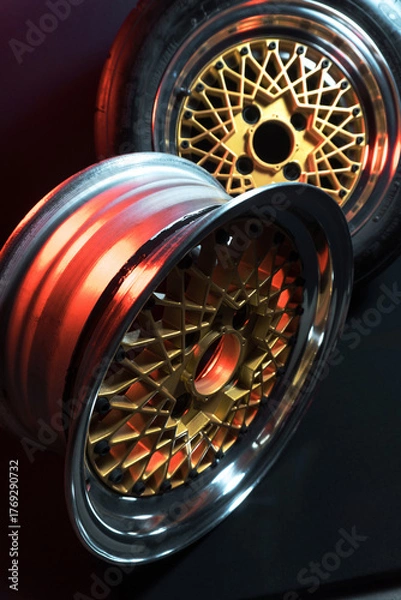 Fototapeta old retro stylish wheels collapsible two-component with a gold center and shiny rims for car tuning long exposure photo to simulate movement