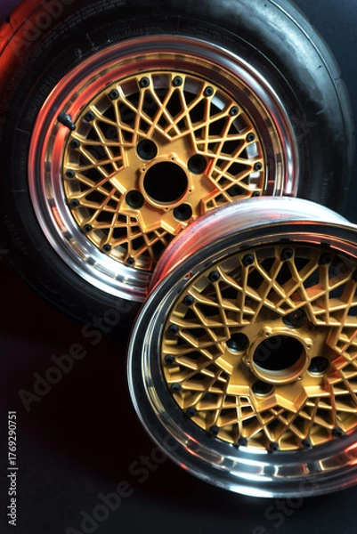 Fototapeta old retro stylish wheels collapsible two-component with a gold center and shiny rims for car tuning long exposure photo to simulate movement