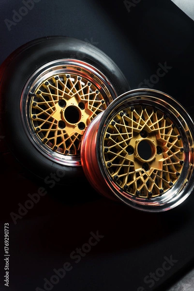 Fototapeta old retro stylish wheels collapsible two-component with a gold center and shiny rims for car tuning long exposure photo to simulate movement
