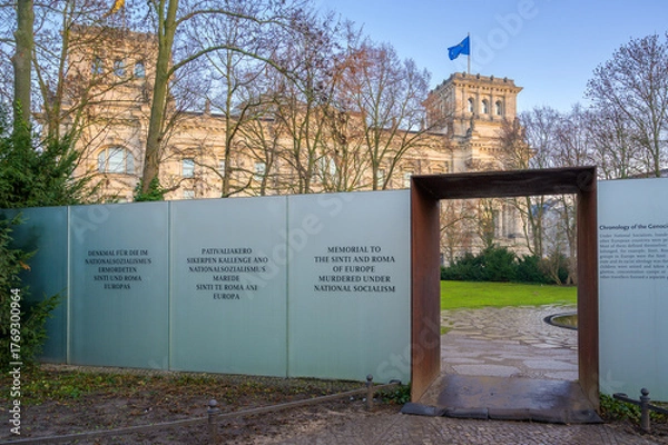 Fototapeta Berlin, Germany - December 20, 2019: Memorial honoring Sinti and Roma stands beside Reichstag Building in early morning light