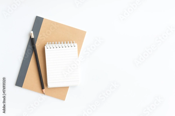 Fototapeta black pencil and notebook paper on brown notebook paper on white background