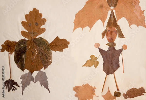 Fototapeta Childish crafts made from dried leaves. Two manikins
