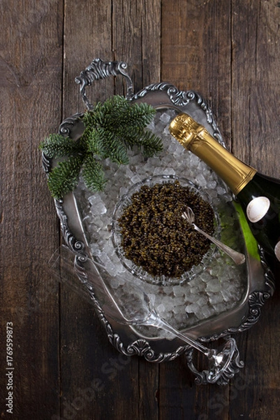 Fototapeta Black caviar and champagne. Caviar on a crystal plate. Ice on a tray. Black caviar on ice. Natural omega. Flat lay. Top view. Copy space.