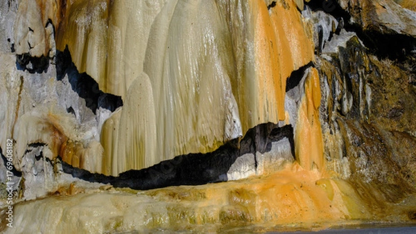 Fototapeta travertine waterfall close-up image, with mineral waters, the waterfall turned into chalky and colorful travertines.