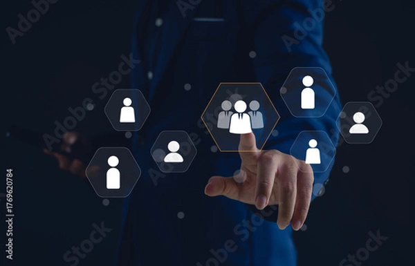 Fototapeta business professional selecting a virtual team icon on a digital interface. Concept of human resource management, recruitment, leadership, teamwork, and digital business networking.