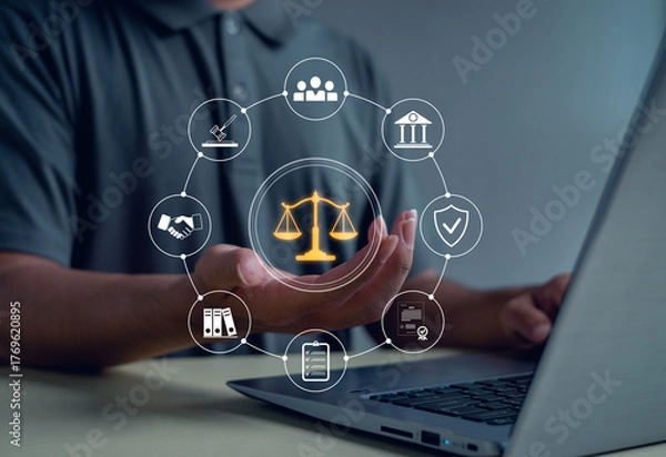 Fototapeta Business person using digital justice scale and law icons above laptop symbolizing legal services, corporate compliance, fairness, protection, and professional consulting in modern technology.