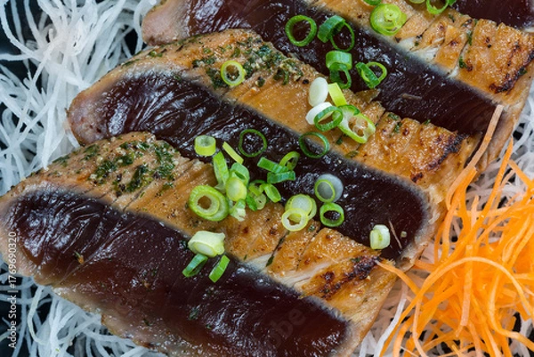 Fototapeta Japanese style of temaki with fillet of mackerel fish served julienned vegetables and leek on black plate, Asian food, traditional Japanese food, close up